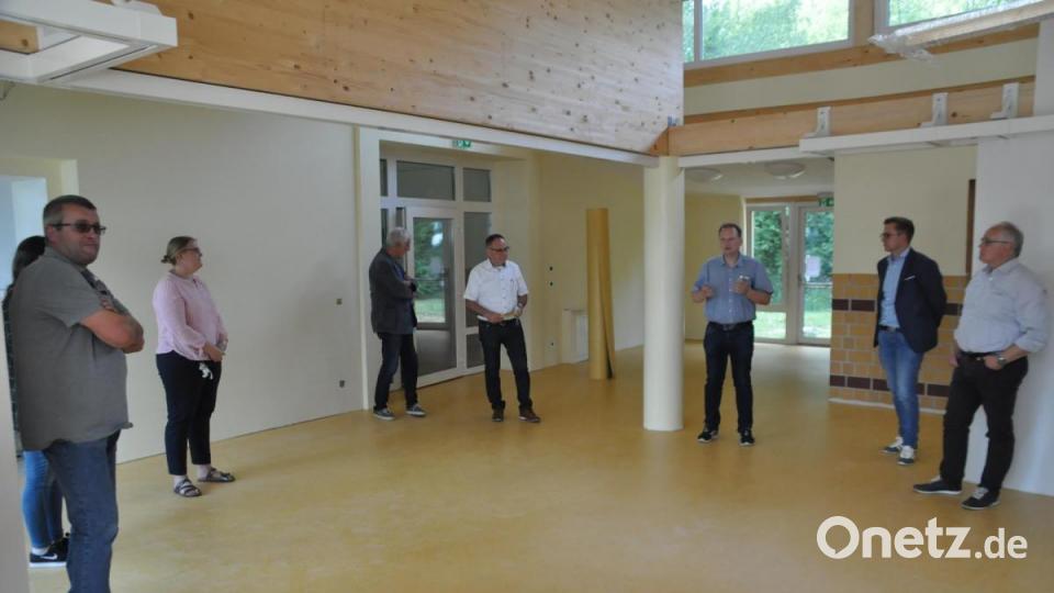 Die Mitglieder des Bauausschusses im erweiterbaren Foyer mit Wolfgang Schultes (Bildmitte, weißes Hemd) und Bürgermeister Christian Porsch (Dritter von rechts). Bild: ak
