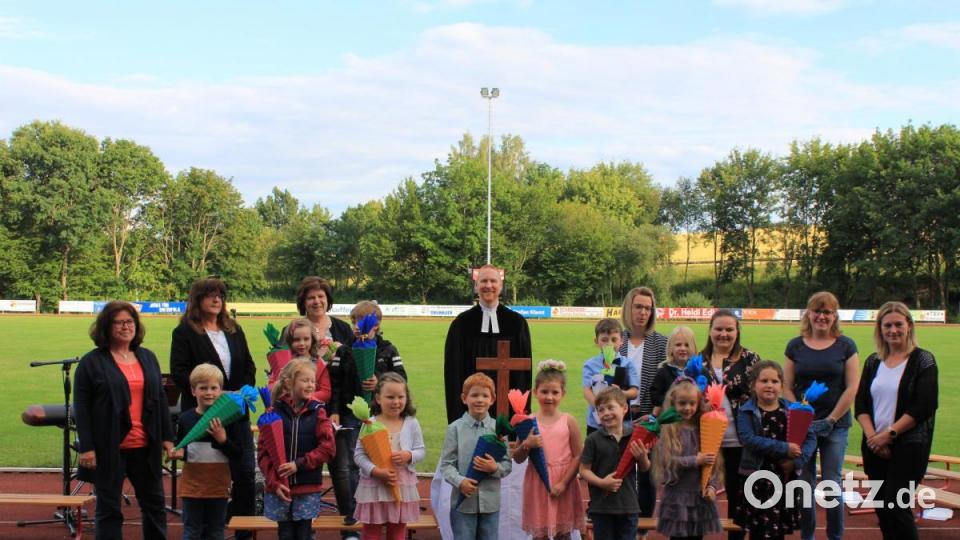 Die zwölf Vorschulkinder wurden mit Schultüte feierlich aus dem Kindergarten verabschiedet. Mit ihnen freuen sich Kindergartenleiterin Brunhilde Mannich (hinten, Dritte von links) mit ihren Mitarbeiterinnen und Pfarrer Christoph Zeh (hinten, Mitte). Bild: fks