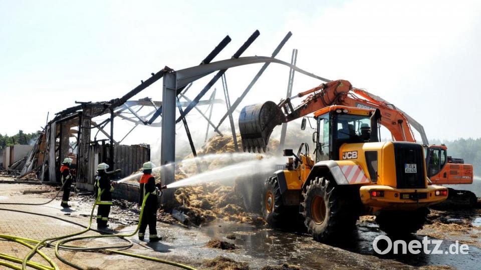Strohballen müssen aus der abgebrannten Halle geholt und vollständig abgelöscht werden. Bild: Stephan Huber