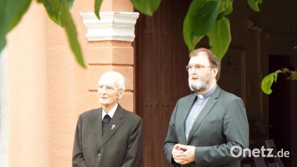 Pfarrer Georg Braun (links) und Diakon Franz-Josef Reck verfolgen das Ständchen der Michelfelder Blasmusik. Bild: Sonja Müller