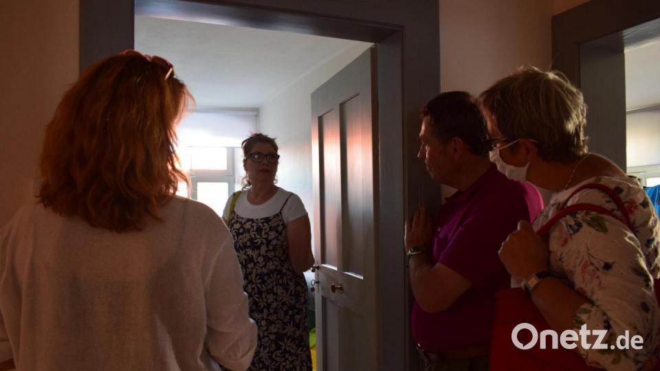 Andrea Altrock (Mitte) gewährt den Gästen bei der Feierstunde gerne einen Einblick in ihre Wohnung. Sie wohnt dort mit ihrem Mann Hans und Hund Gismo. Bild: szl