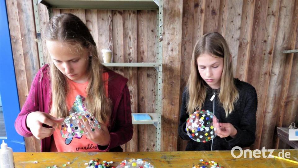 Die Schwestern Valentine (15) und Paulina (13 v. li.) aus Waldhurn haben viel Spaß beim Bestücken der Kugeln mit Mosaik. Die Mädchen erzählen, dass ihnen auch während Corona daheim nicht langweilig sei, weil sie noch drei weitere Geschwister haben. Bild: ubb