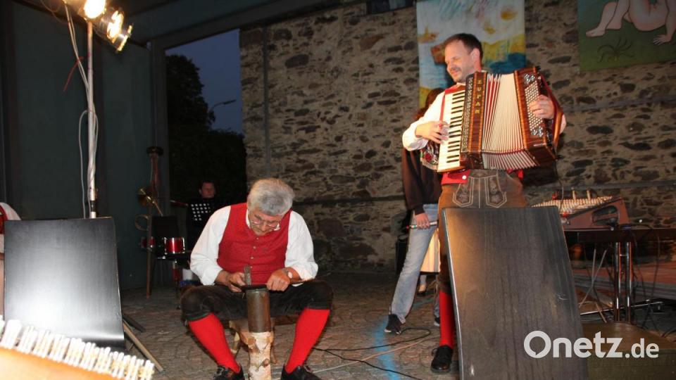 Nach seiner Philosophie über das „Sengstdengeln“ zeigte Anderl Ebnet, musikalisch begleitet von Martin Ebenhöch, dass er das Schärfen einer Sense auf dem Dengelbockl auch in der Praxis beherrscht. Bild: frd