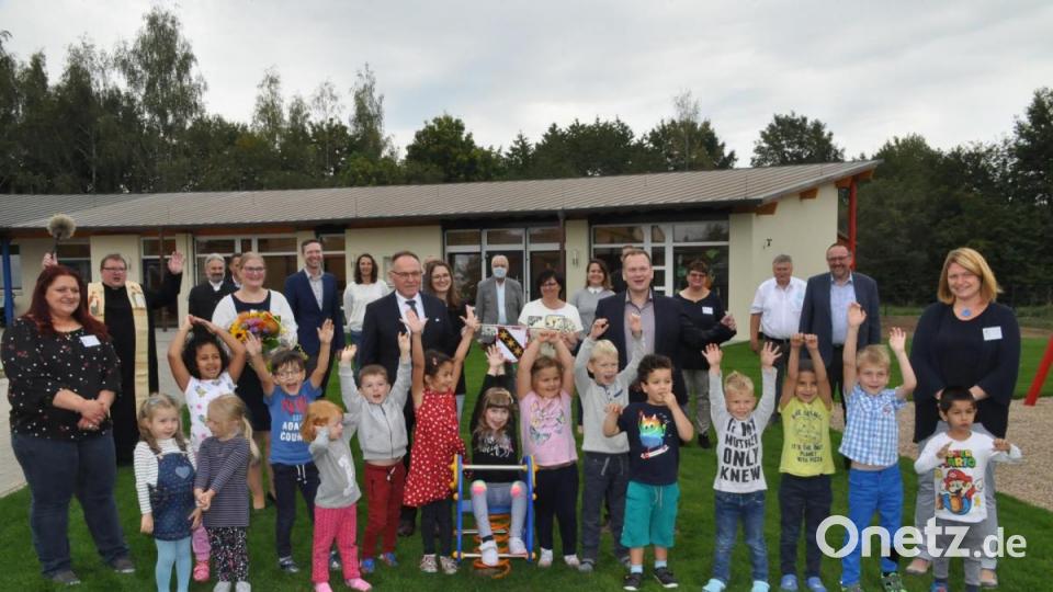 Vor allem die Mädchen und Buben freuten sich bei der Einweihungsfeier über den gelungenen Kindergartenanbau (Hintergrund). Bild: ak