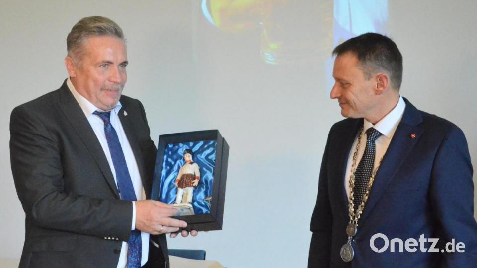 Oberbürgermeister Jens Meyer (rechts) schenkt seinem Amtskollegen aus Annaberg-Buchholz, Rolf Schmidt, einen Knappen aus Porzellan. Bild: Kunz