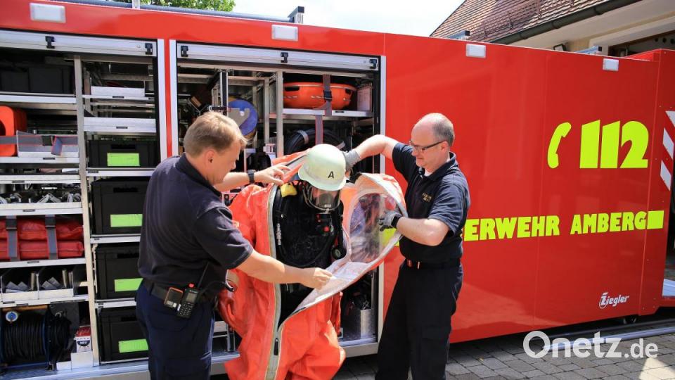 KBM Alexander Graf (links) und Michael Werner Feuerwehr Amberg (rechts) helfen dem Chemikalienschutzanzugträger aus dem Anzug. Bild: egl
