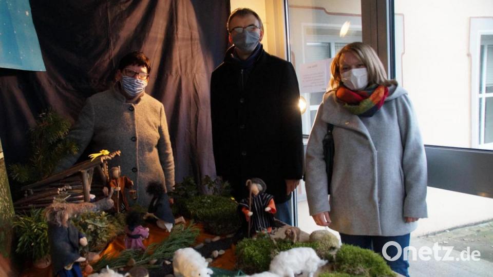 Roswitha Heining, Pfarrer Martin Besold und Kathrin Götzl (von links) blicken gespannt in die Krippe im Kolpinghaus. Bild: kaz