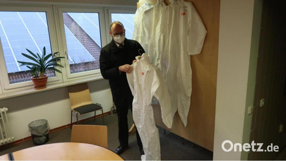 Landrat Andreas Meier mustert die Corona-Schutzkleidung, die in manchen Fällen bis zu sieben Stunden täglich getragen werden muss. Bild: Kunz
