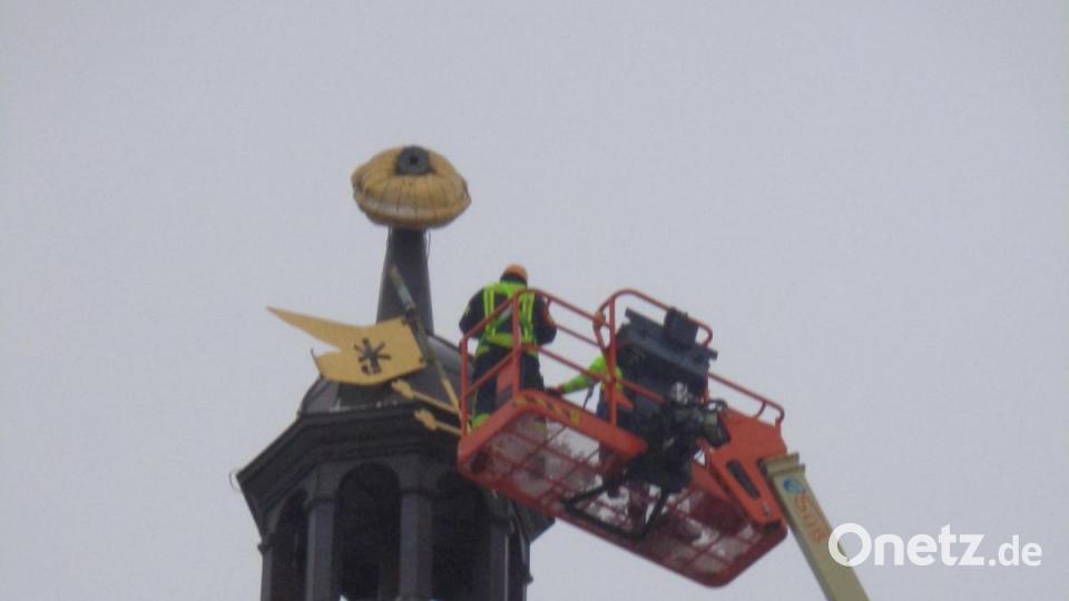 Die Einsatzkräfte Stephan Killermann und Markus Mädl sind mit Hilfe einer Hebebühne bei der Kirchturmspitze angekommen. Bild: amö