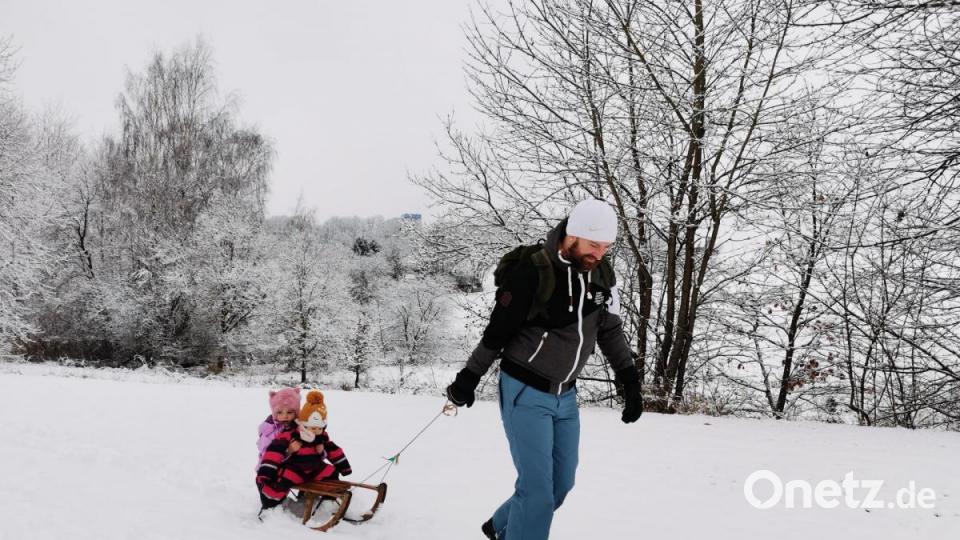 Emilia und Sophia lassen sich am 7. Januar vom Papa auf dem Holzschlitten über die tiefverschneite Wiese oberhalb des Marktweihers ziehen. Bild: Portner