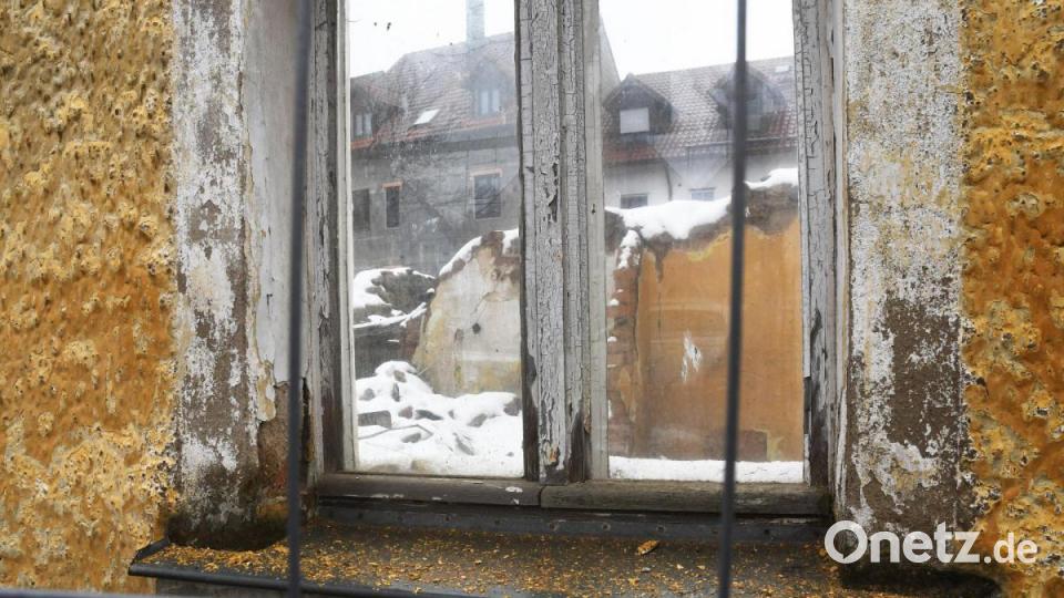 Durchs Absperrgitter und ein Fenster des eingestürzten Hauses geht der Blick auf die gegenüberliegenden Mauereste. Bild: Gabi Schönberger