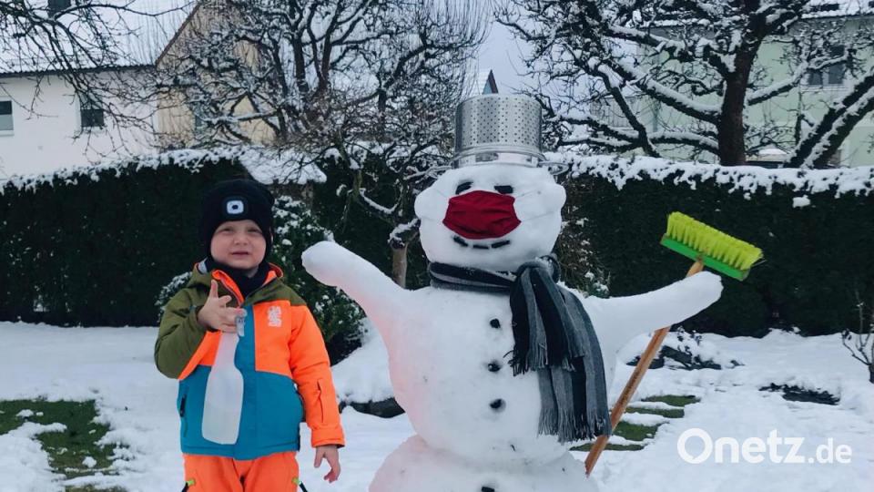 Mit Opa Reimund Zeitler hat Paul Zeitler diesen coronakonform mit Maske ausgestatteten Schneemann in Windischeschenbach gebaut. Bild: Reimund Zeitler/exb