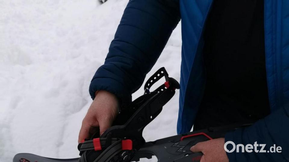 Ernst Meindl erklärt die Handhabung der Schneeschuhe. Bild: Portner