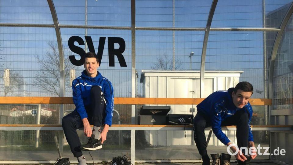 Tim und Leon Schreiner sitzen im Pandurenpark beim SV Raigering auf der Bank und schnüren ihre Schuhe in Größe 50. Bild: roa