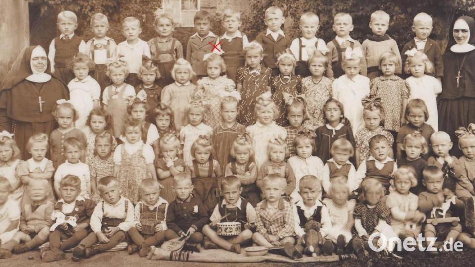 Die historische Fotografie wurde um 1943 neben dem Kirchenschiff bei der Mariengrotte aufgenommen und zeigt 62 Kinder, die im Ebnather Kindergarten von zwei Niederbronner Schwestern betreut wurden. Darunter befindet sich auch die Großmutter von Tobias Damberger, Marianne Kuhbandner (zweite Reihe von oben, fünftes Kind von links), die sich auch heute noch gerne an Schwester Maria Martha (links) erinnert, der Name der anderen Schwester (rechts) ist ihr leider entfallen. Repro: soj