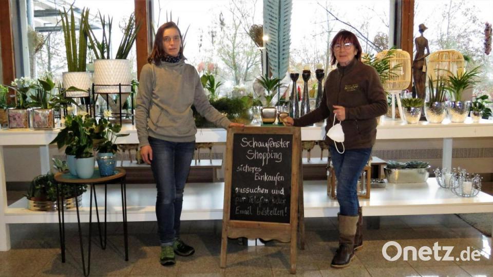 Nicole Punzmann und Lisa Schröpf (v. li.) haben ihr Schaufenster großzügig mit vielen Blumen- und Pflanzenbeispielen ausgestattet. Ein Schild vor der Tür weist aufs &quot;Schaufenster-Shopping&quot; hin. Bild: ubb
