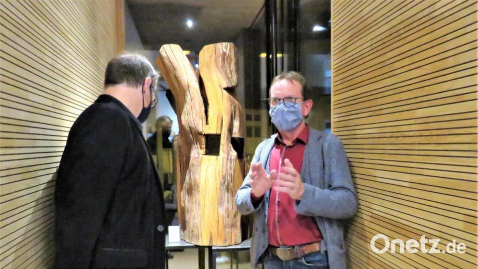 Vorsitzender Wolfgang Horn (rechts) stellte Bernd Sommer die Idee hinter seiner bearbeiteten Holzskulptur vor. Bild: ubb