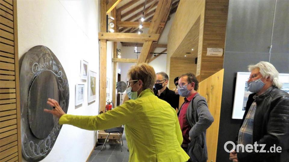 Künstlerin Regina Zrenner beschreibt Bürgermeister Bernd Sommer, Vorsitzendem Wolfgang Horn und dem Künstlerkollegen Tom Brankovic (von links), was sie mit ihrer großflächigen Metallarbeit aussagen möchte. Bild: ubb