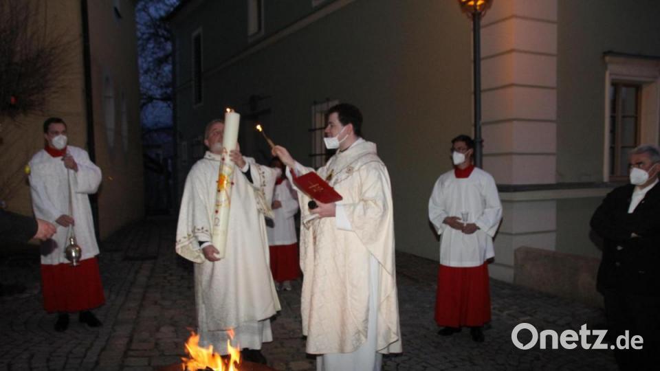 Am von ihm gesegneten Osterfeuer entzündete Kaplan Florian Fronhöfer (rechts) die Osterkerze. Bild: frd