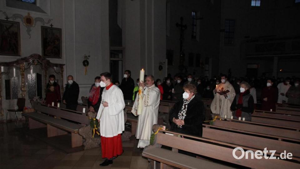 Mit der am Osterfeuer entzündeten Osterkerze zogen Kaplan Florian Fronhöfer, Diakon Ulli Wabra und die Ministranten in die abgedunkelte Pfarrkirche ein. Bild: frd