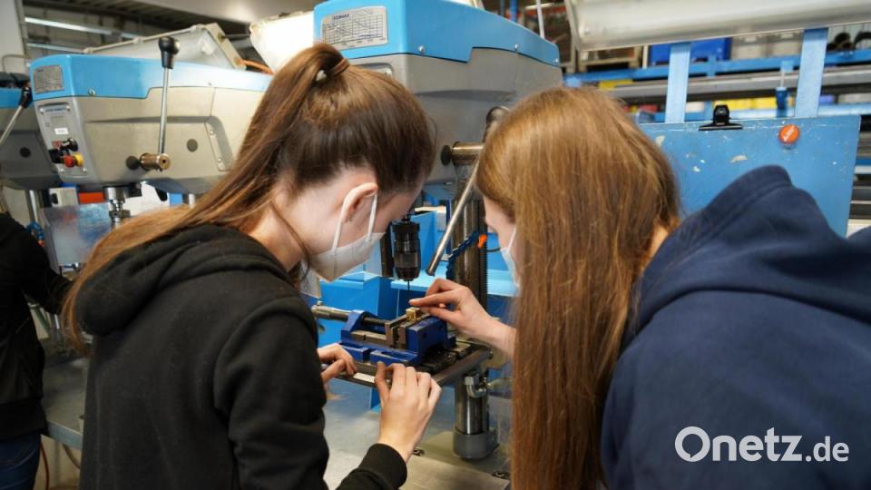 An einer Ständerbohrmaschine zeigt Kathrin Hofmann Lena Schaller, wie sie die Augen in den Spielwürfel bohren kann. Bild: kaz