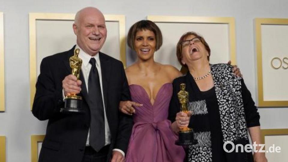 Donald Graham Burt (l), Artdirector, und Jan Pascale (r), Szenenbildnerin, posieren im Presseraum mit dem Oscar für das beste Produktionsdesign für &quot;Mank&quot; mit Schauspielerin Halle Berry in der Union Station. Bild: Chris Pizzello/Pool AP/dpa