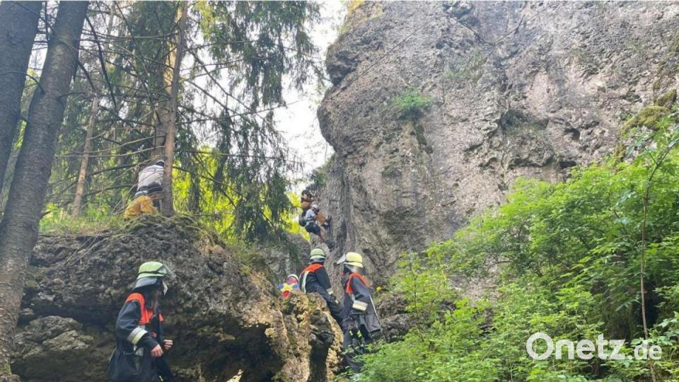 Helfer vor der Wand am Höhenglücksteig, in der einen Kletterer am Dienstagabend die Kräfte verlassen haben. Bild: lei