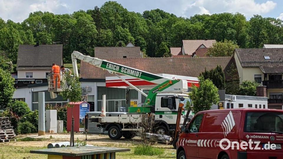 Mit Hilfe einer Arbeitsbühne werden der Mast und die Sirene im Ortskern von Eschenfelden errichtet. Bild: lei