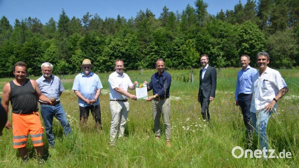 Bürgermeister Christian Porsch erhielt aus den Händen von Umweltminister Thorsten Glauber (Vierter und Fünfter von links) die Dankurkunde. Mit dabei Mitarbeiter des Bauhofes und der Verwaltung, Vereinsvertreter, DVL-Manager Martin Sommer (rechts) und Landrat Florian Wiedemann (Dritter von rechts). Bild: ak