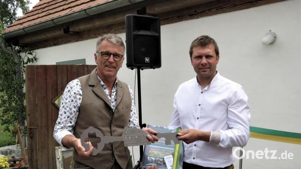 Bürgermeister Franz Stahl (links) überreichte dem Ortssprecher von Hohenwald, Johannes Bäuml, den symbolischen Schlüssel fürs Hirthaus. Bild: ubb