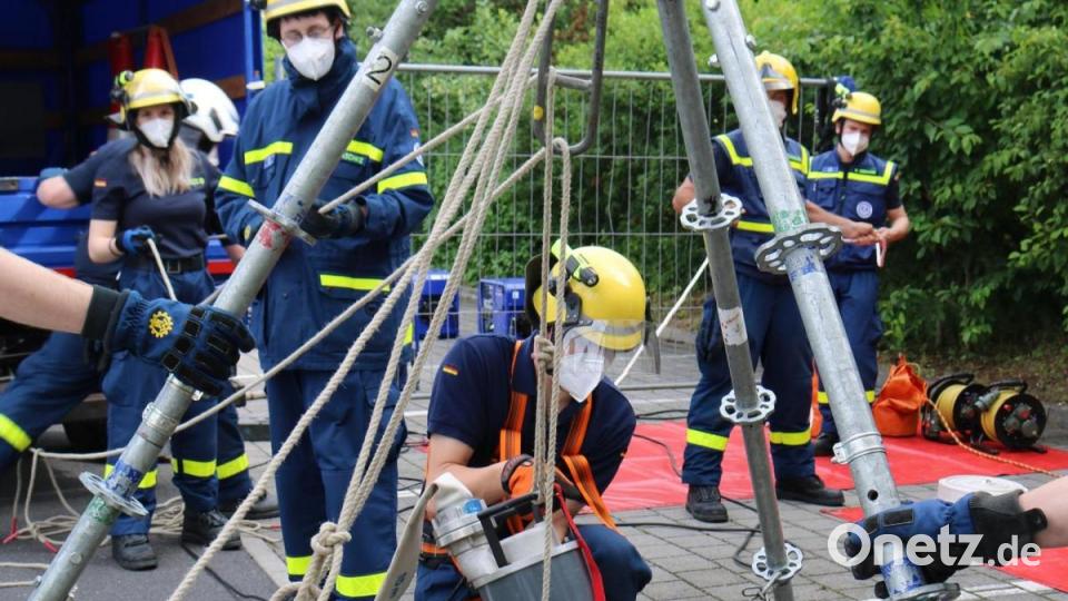 Über einen Dreibock aus Einsatzgerüststangen werden die
Schmutzwasserpumpen in den Tank hinabgelassen. Sowohl der THW-Helfer als auch die
Pumpe sind über Leinen vor einem Absturz gesichert. Bild: Christian Birner