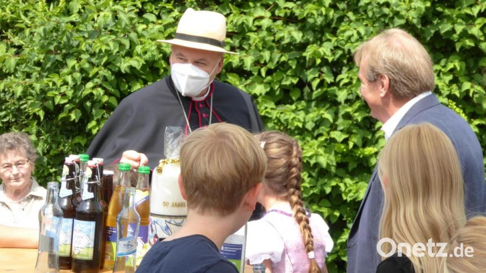 Bischof Voderholzer mischt sich mit Sonnenhut und Maske unter die Gäste. Bild: fsb