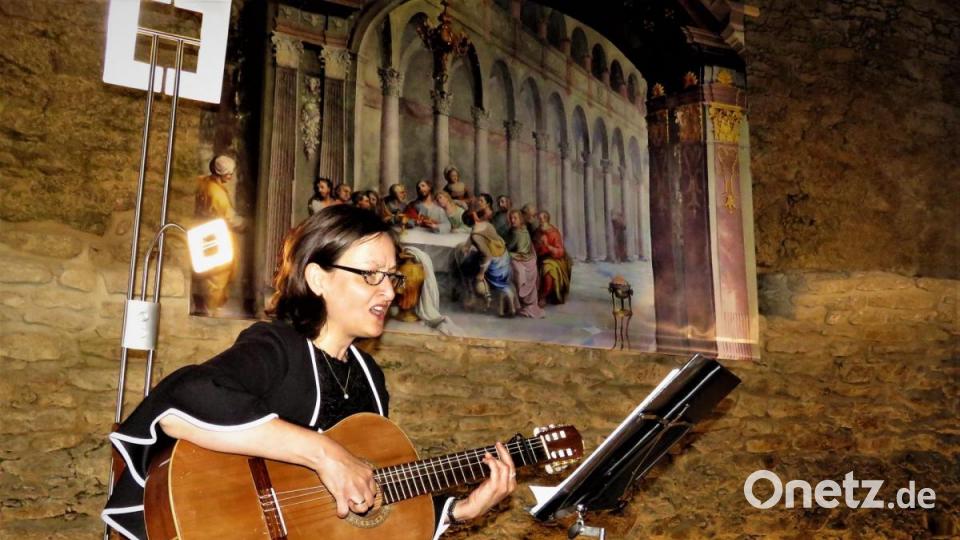 Die Mezzosporanistin Christine Kohl gestaltete die Vernissage mit einfühlsamen Kirchenliedern, passend zum Thema &quot;Kirchenmalerei&quot;. Im Hintergrund ist eine Ablichtung des größten und imposantesten Werkes von Fuchs, das Abendmahl, zu erkennen. Der Künstler hat es auf eine Fläche von sechs mal acht Metern für das Refektorium des Klosters Tepl gemalt. Bild: ubb