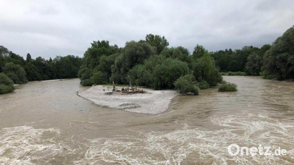 Braune Wassermassen fließen in der Isar in München an einer Insel am Flauchersteg entlang. Bild: Manuel Schwarz