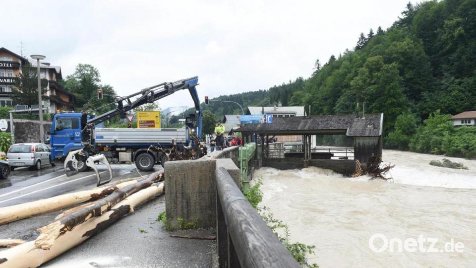 Berchtesgaden: Ein Baumstamm wird bei Unwetter und Hochwasser in Bayern im Berchtesgadener Land aus dem Wasser geholt. Bild: Felix Hörhager