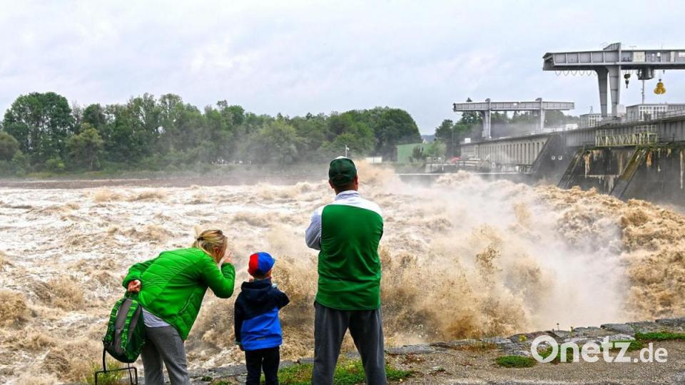 Braunau am Inn: Menschen stehen an der Staustufe Ranshofen. In vielen Teilen Österreichs hat eine Starkregenfront für Hochwasser gesorgt. Bild: Manfred Fesl/APA/dpa