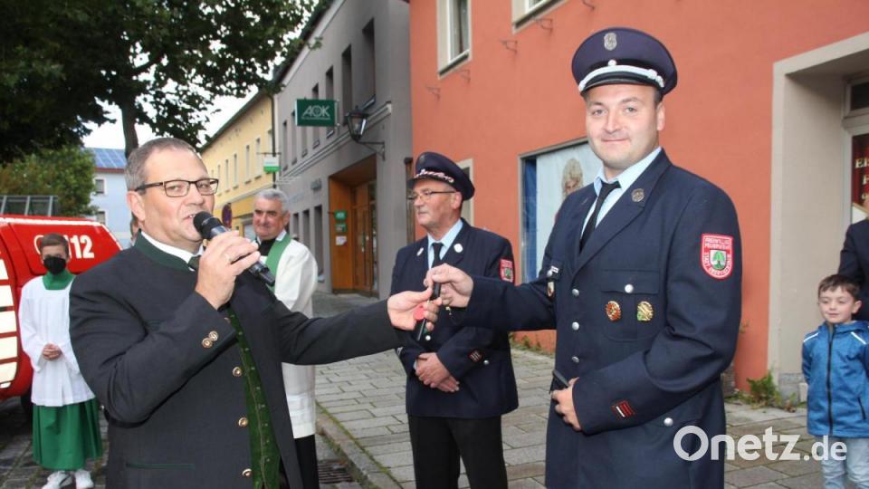 Zweiter Bürgermeister Egbert Völkl (links) übergibt an Kommandant Ferdinand Roßmann (rechts) die Schlüssel für die beiden neue Fahrzeuge. Dahinter Feuerwehr-Vorsitzender Hans Roßmann. Bild: frd