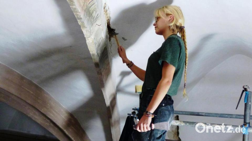 Celine Seibold, Restauratorin und Kirchenmalerin, arbeitet mit Hämmerchen und Spachtel, um den schadhaften Verputz abzuschlagen und zu ersetzen. Bild: jp