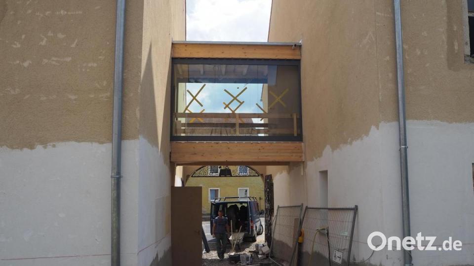 Zurückhalten gibt sich die verglaste Brücke, die beide Gebäudeteile verbindet und damit auch den Zugang zum Aufzug sicherstellt. Bild: bl
