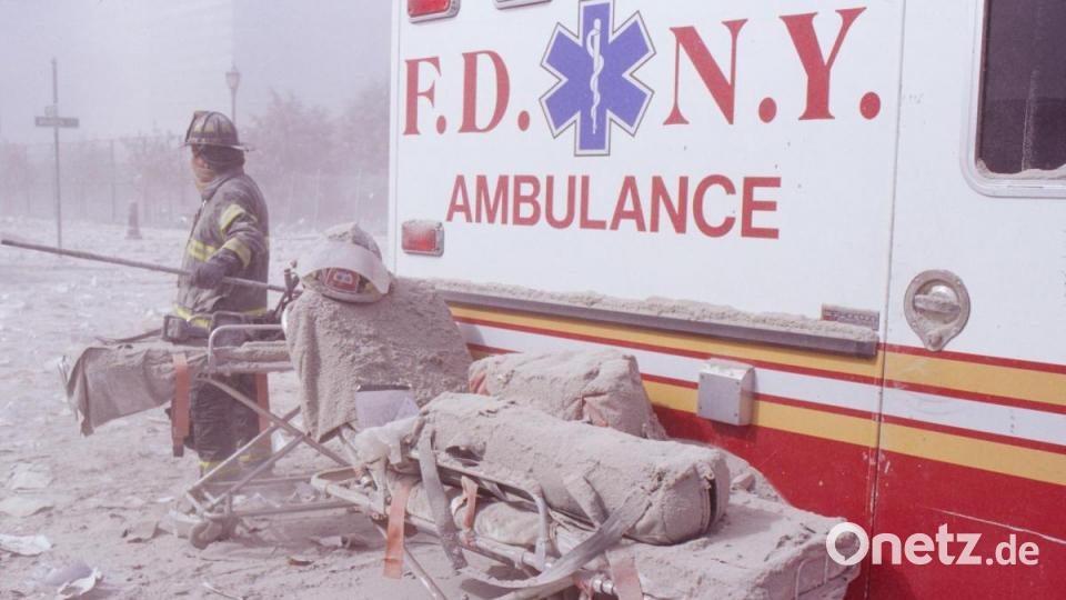 Eine staubbedeckte Krankentrage und ein Feuerwehrmann stehen nach dem Terroranschlag auf das World Trade Center neben einem Rettungswagen. Archivbild: Randy Taylor/ZUMA Press Wire Service/dpa