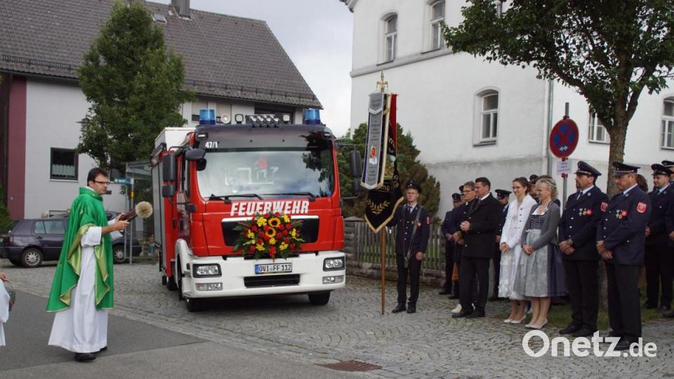 Nach Gebet und Fürbitten besprengte Pfarrer Wolfgang Dietz das neue Fahrzeug der Feuerwehr Weiding mit Weihwasser. Bild: mmj