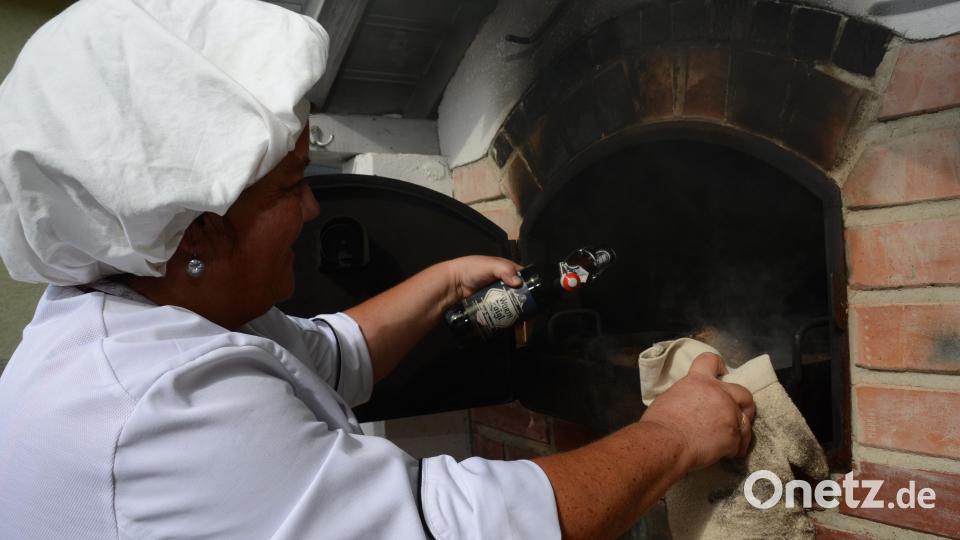 Birgit Baier kippt noch einen Schuss Zoigl über das Bratenfleisch im heißen Backrohr. 300 Portionen mit 600 Knödel werden zur Mittagszeit an Hungrige abgegeben. Bild: doj