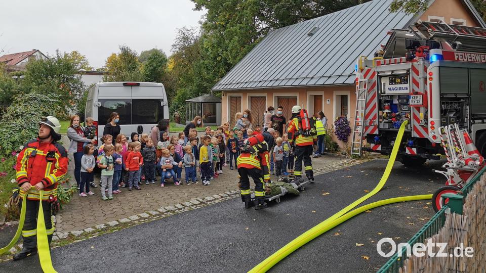 Mit einer Trage bringen Atemschutzträger die Übungspuppe aus dem Kindergarten. Wenige Minuten davor waren die Kinder selbst aus dem Kindergarten &quot;geflohen&quot;: Ein Rauchmelder hatte Alarm geschlagen, nachdem dieser den &quot;Rauch&quot; einer Nebelmaschine registriert hatte. Bild: mde