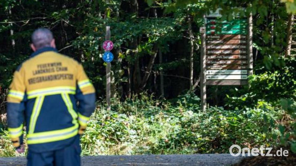 Ein Feuerwehrmann steht an einem Wanderweg. Bei einer Wanderung am tschechischen Berg Cerchov ist am 10.10.2021 ein achtjähriges Mädchen aus Berlin verschwunden. Die Polizei durchkämmt seitdem das unwegsame Waldgebiet an der bayerisch-tschechischen Grenze. Bild: Armin Weigel/dpa