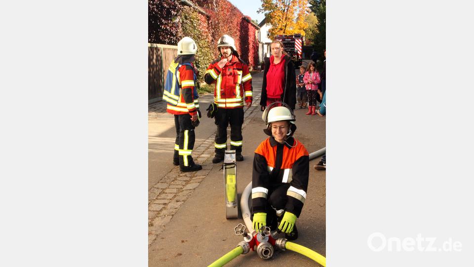 Der Schlauch ist prall gefüllt, die erfahrenen Feuerwehrleute haben ein Auge auf den Nachwuchs. Bild: zer