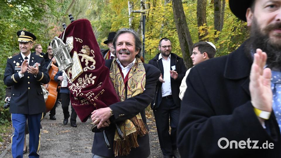 Begleitet von Musik, Gesang, Tanz und Klatschen brachten Vertreter der israelitischen Gemeinde, hier deren Vorsitzender Ignaz Berger (Mitte), die restaurierte Tora-Rolle zu Fuß vom ACC zurück an ihren Platz im Herzen der Stadt, in die Synagoge am Salzstadelplatz. Bild: Petra Hartl