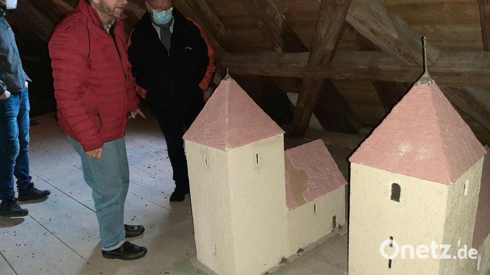 Auf dem Dachstuhl über dem Langhaus finden sich Modelle der früheren Kirche. Pfarrer Stohldreier (links, rote Jacke) erklärt die Unterschiede. Bild: ise