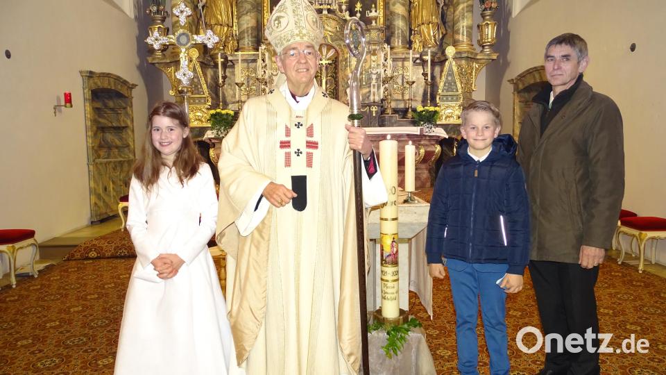 Erzbischof Ludwig Schick neben der Jubiläumskerze und zusammen mit den drei Michelfeldern, die ihn im Namen der Pfarrei begrüßten: die Kommunionkinder Sophie Höllerl und Dominik Weber sowie Pfarrgemeinderatsvorsitzender Erwin Holl. Bild: ll