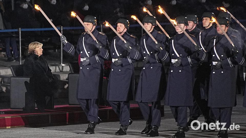 Die Soldaten des Wachbataillon der Bundeswehr marschieren mit Fackeln auf. Mit einem Großen Zapfenstreich wird Kanzlerin Merkel gegen Ende ihrer Regierungszeit nach 16 Jahren im Bendlerblock verabschiedet. Bild: Michael Kappeler/dpa