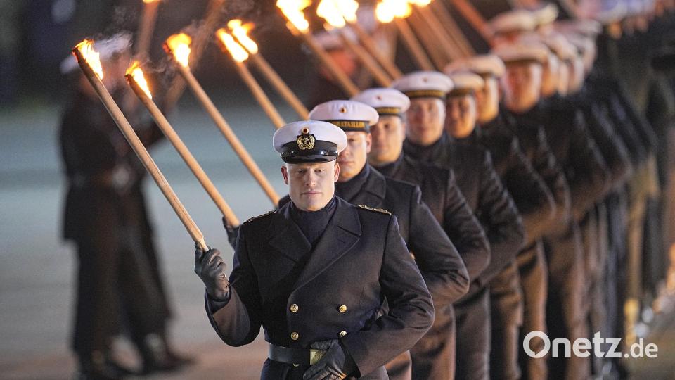 Die Soldaten des Wachbataillon der Bundeswehr marschieren mit Fackeln auf. Bild: Michael Kappeler/dpa